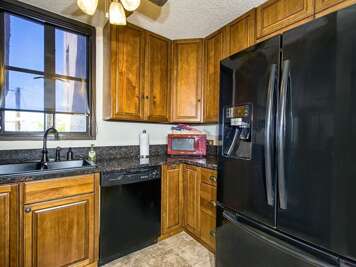 Wood Cabinets, Black Appliances, Window View