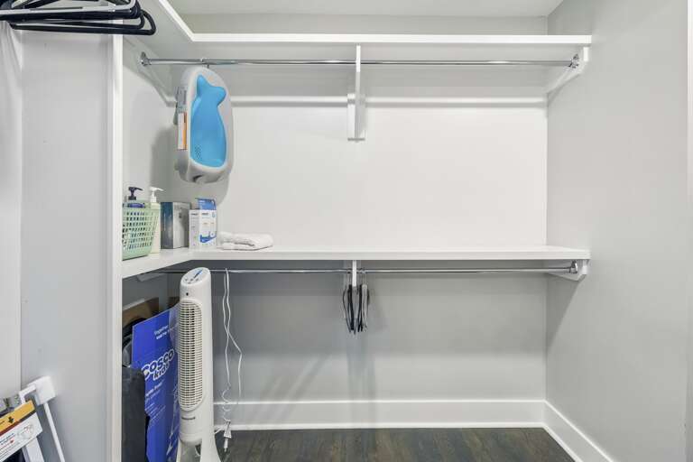 Generous shelving and dual hanging rods provide extra space for all your belongings - Clean white finishes and wood flooring create a crisp, organized storage area - Ideal for longer stays, offering plenty of room for suitcases, shoes, and wardrobe