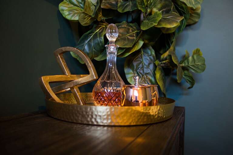 - Touch of glam meets cozy charm in this golden moment of style and sparkle - Elegant glassware, metallic accents, and beautiful greenery bring warmth to the space - Perfect for sipping, styling, or simply setting the mood, cheers to the little details