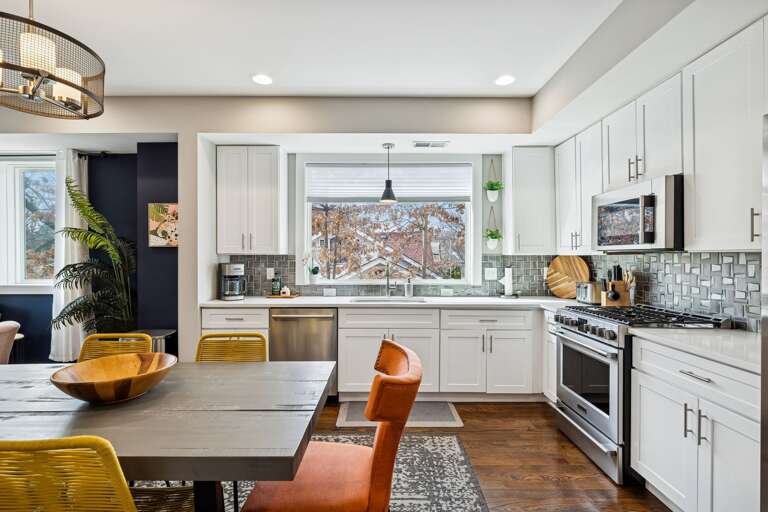 - Bright, modern kitchen with oversized window, stainless appliances &amp; cheerful vibes - Gather around a bold dining table with eclectic chairs &amp; playful textures - Perfect flow into the cozy living space, ideal for sharing meals &amp; memories