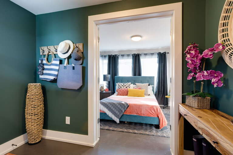 - Step into vacation mode with this vibrant entryway full of beachy charm - Hooks for your hats, totes, and sunnies make it easy to drop and go - Peek into a bold, inviting bedroom ready to recharge your energy and style