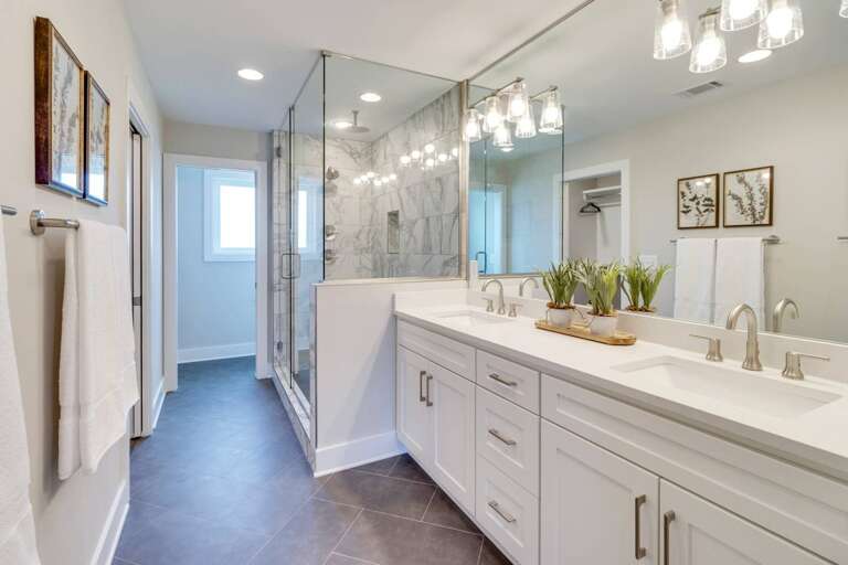 - Refresh in a spacious bathroom featuring a sleek double vanity and large mirror - Walk in glass shower with marble style walls adds spa like serenity to your stay - Soft towels, warm lighting, and greenery bring a calming, clean atmosphere