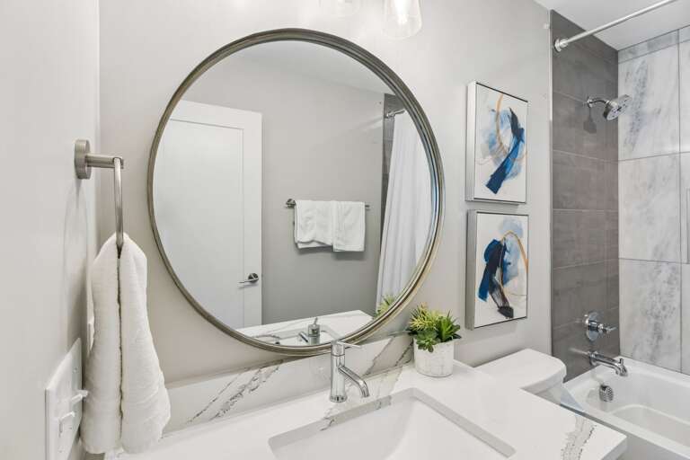 Step into the third full bathroom and you'll get the same clean finish as the rest of the house — tub-shower combo, white tile, ready for your group.
