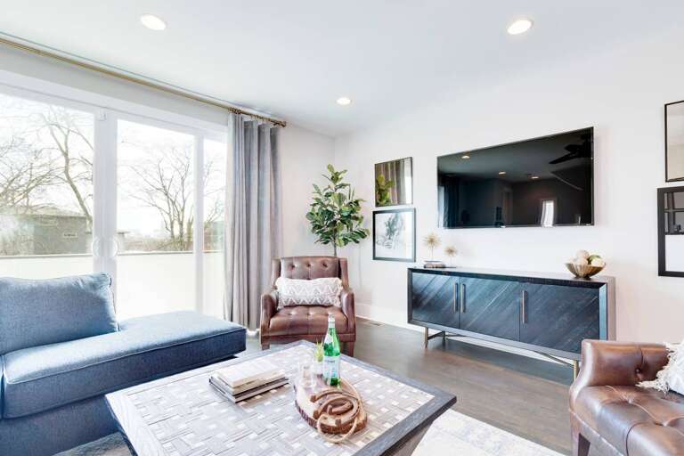 The open living area has a sectional sofa and a 65" 4K SmartTV