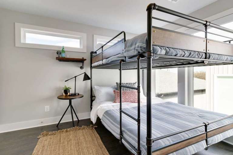 3rd floor bedroom consisting of two queen bunk beds, a laptop-friendly workspace, and two closets