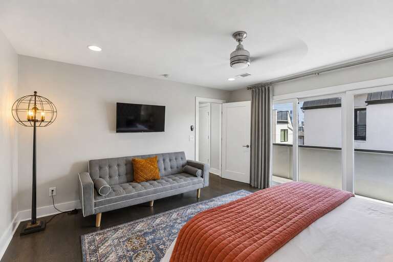 Claim the king bedroom and you get your own sofa, wall TV, and private bath — no sharing required for whoever stays in here.