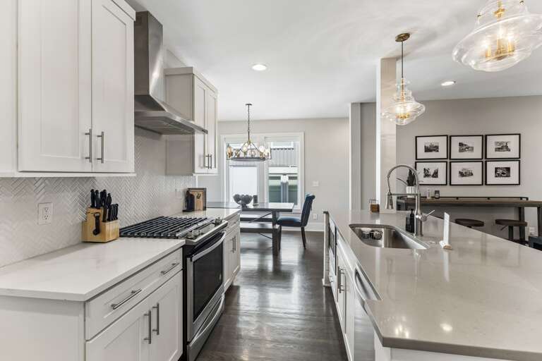 You've got a real gas range for whoever wants to cook — stainless steel burners, herringbone backsplash, and a kitchen that doesn't make you feel like you're roughing it.