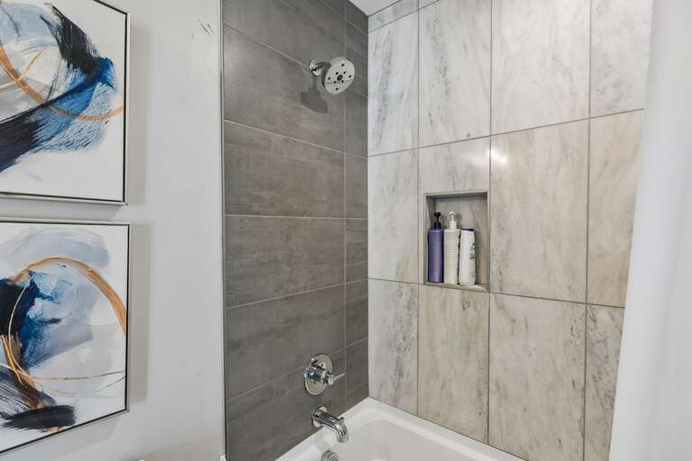 Step into the third full bathroom and you'll get the same clean finish as the rest of the house — tub-shower combo, white tile, ready for your group.