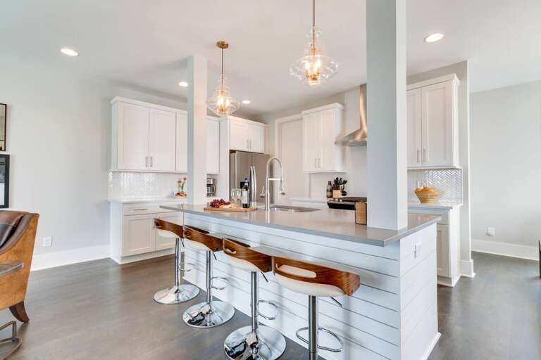 - Sleek white cabinetry &amp; quartz countertops make this kitchen a dream for any chef - Oversized island with stylish wood &amp; chrome stools perfect for casual dining or drinks - Pendant lighting &amp; stainless steel appliances complete the upscale m