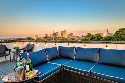 - Soak up city skyline views from a plush sectional as the sun dips below the horizon - String lights and cozy seating create the ultimate vibe for evening drinks and chats - Enjoy wine, bubbly, and fresh fruit with the sparkling city as your backdrop