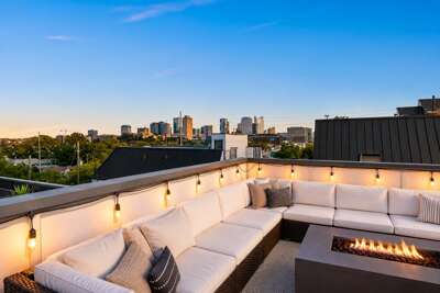 Your private rooftop at golden hour — fire pit glowing, wine on ice, and the Nashville skyline waiting on you.