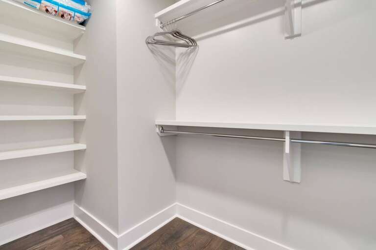 - Spacious walk in closet offers extra shelving for shoes, bags, and essentials - Double hanging rods provide plenty of room for organizing clothes with ease - Clean design with hardwood floors keeps storage looking sleek and tidy