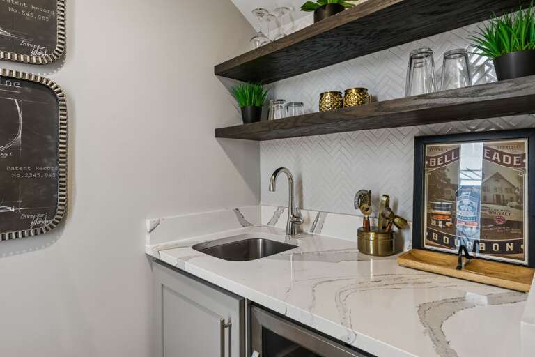 Stock the rooftop wet bar and you won't need to go back downstairs — quartz counter, glassware ready, beverage fridge stocked, and the skyline waiting.