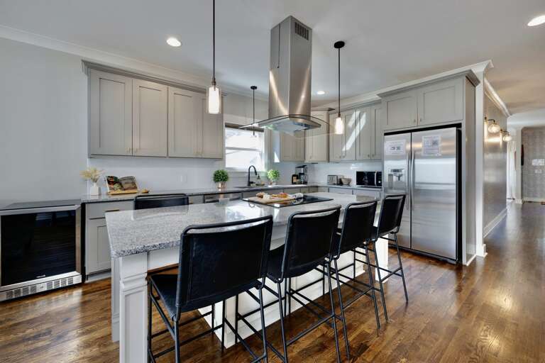 - Spacious chef’s kitchen with full stainless steel appliances and elegant cabinetry - Oversized island with granite top and seating, perfect for group gatherings - Warm wood floors and pendant lights add modern charm to every meal