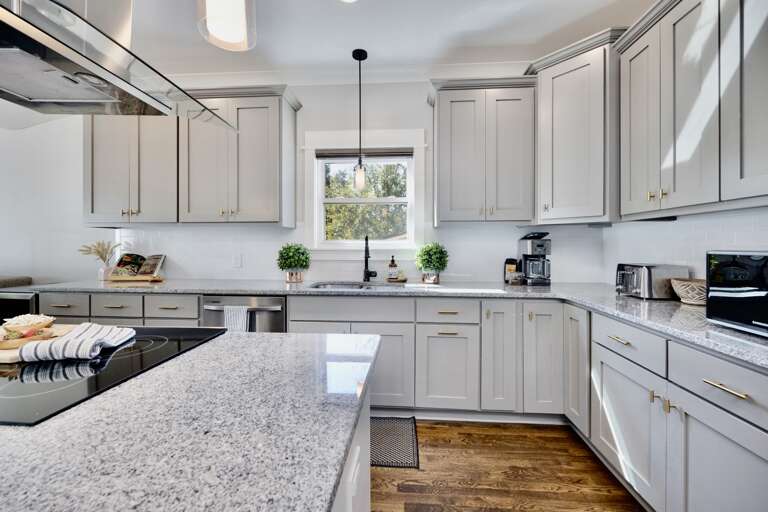 - Stylish kitchen with shaker cabinets, granite countertops, and warm wood floors - Natural light pours in through the window, brightening every culinary moment - Coffee station in the corner makes mornings easy and energized