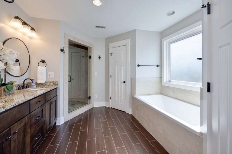 - Soak your cares away in the deep tub or step into the luxe walk in shower for a spa like escape - Warm wood style floors and soft lighting create a calming retreat - Stunning space that blends comfort, style, and function effortlessly