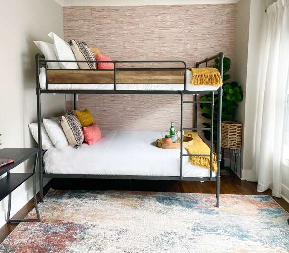 - Double the fun with this dreamy bunk setup, fluffy beds, sunlit style, and bold personality - Welcome tray with sparkling water and a pop of greenery adds boutique flair - Designed for giggles, great sleeps, and unforgettable memories