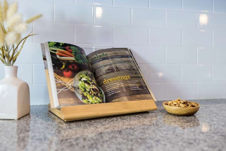 - Flip through the colorful recipe book and get inspired to cook something fresh - Set on a wood stand beside a modern vase and snack bowl for a warm welcome - Stylish details blend practicality with charming presentation