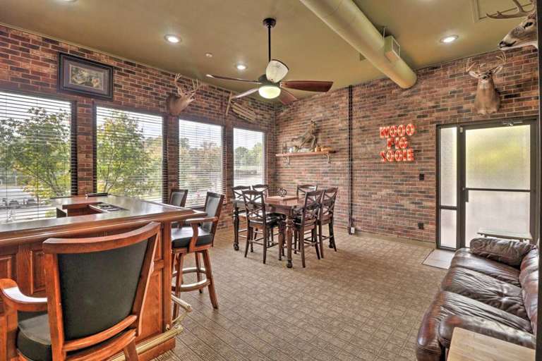 Brick-walled Room With Bar Seating, Dining Table, And Taxidermy Decor Brick-walled Room With Bar Seating, Dining Table, And Taxidermy Decor