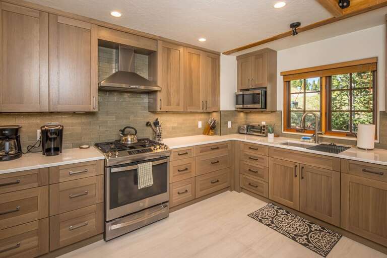 The kitchen is gorgeous with wooden cabinets, beautiful countertops and lovely backsplash | Main Level The kitchen is gorgeous with wooden cabinets, beautiful countertops and lovely backsplash | Main Level
