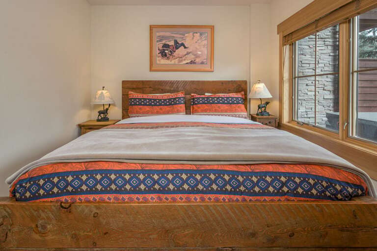 Bed With Patterned Pillows, Wooden Frame, Window View