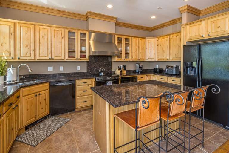 Spacious kitchen with an island and bar seating for three people | Main Level