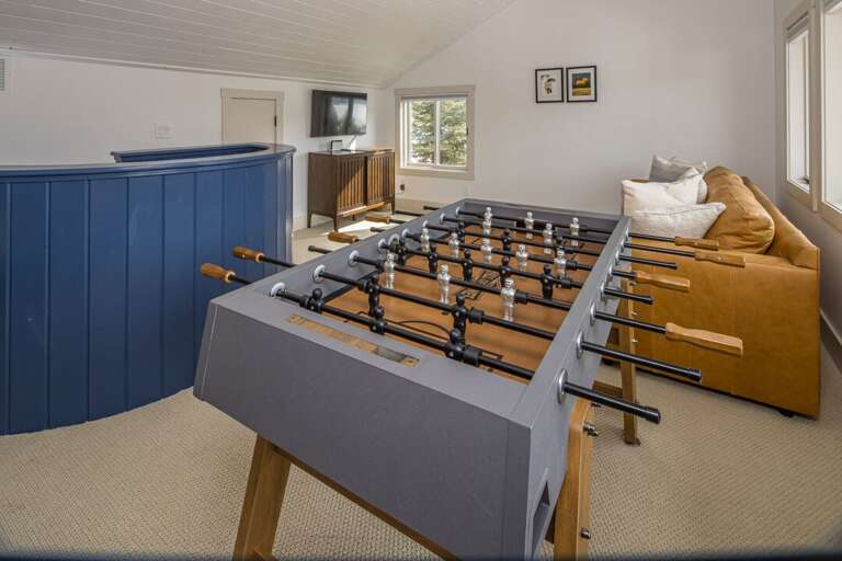 East loft includes couch, foosball table and smart TV, creating a perfect escape for the kids | 3rd Level