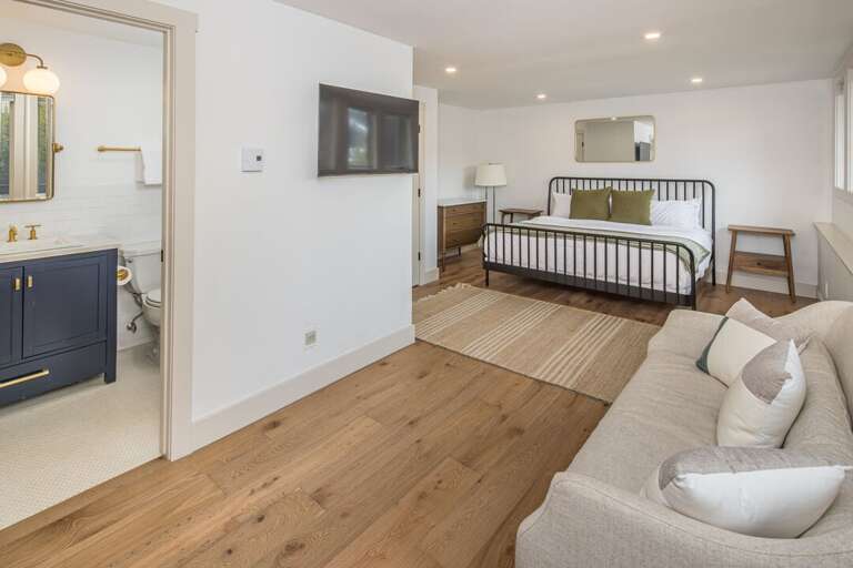 King bedroom equipped with a TV and couch to create a quiet escape | Lower Level