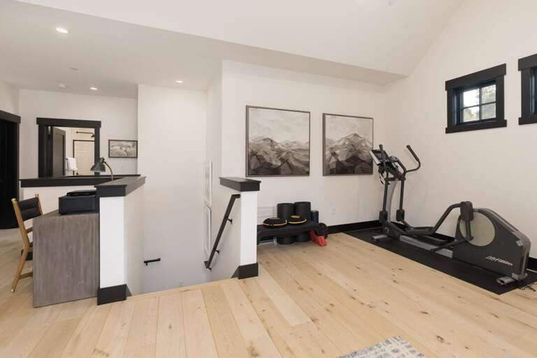 In-home gym equipped with an elliptical machine and weights | Upper Level