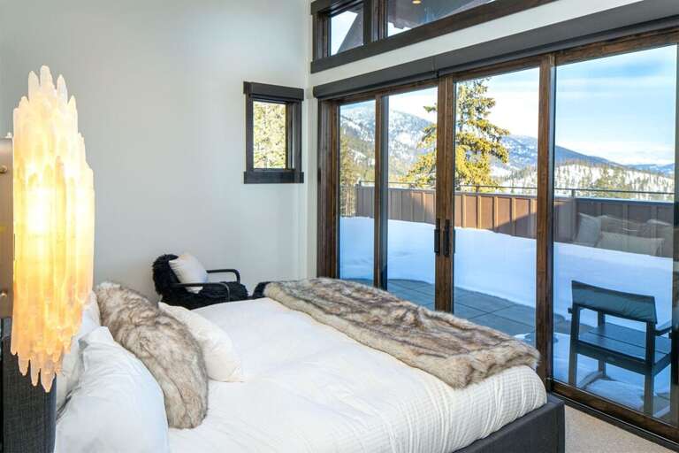 Bedroom 2 has a king size bed and patio access that looks east towards Glacier National Park | Main Level