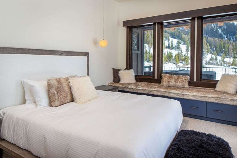 The impressive master bedroom features panoramic mountain views & a built-in window seat | Main Level