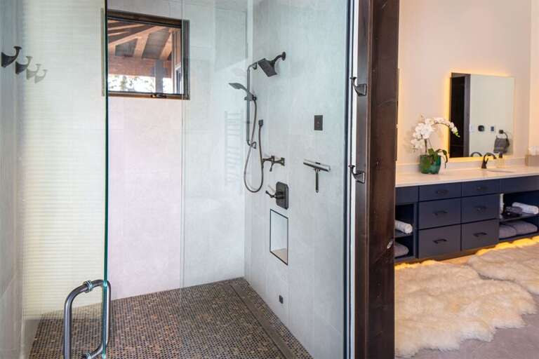 The luxurious master bathroom has a walk-in custom tile shower | Main Level
