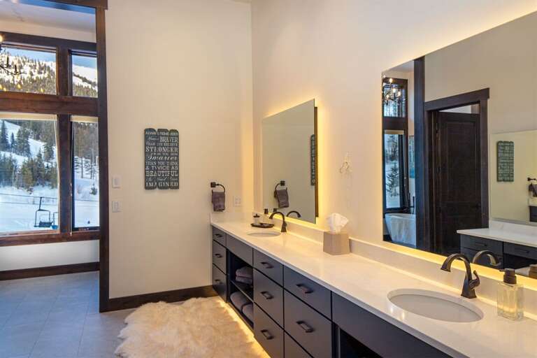 The master bathroom boasts a walk-in shower with custom tile, soaker tub, double vanity, electric toilet & heated floors | Main Level