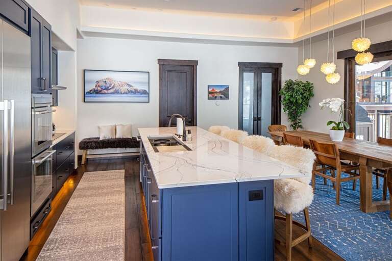 The oversized kitchen island provides seating for four in cozy, custom sheep skin barstools | Main Level