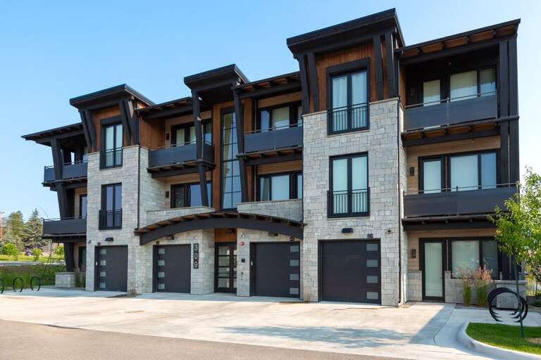 Three-story Structure Boasting Balconies And Brick Base