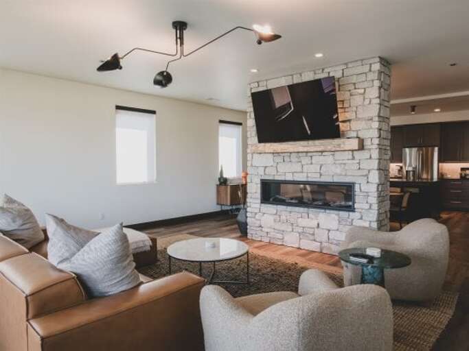 The pass-through fireplace connects the modern living room & dining area | Main Level