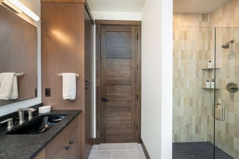 The primary bathroom features a walk-in shower, double vanity & heated floors | Main Level
