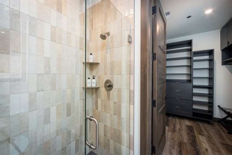 The primary bedroom ensuite offers a walk-in custom tile shower & oversized closet | Main Level