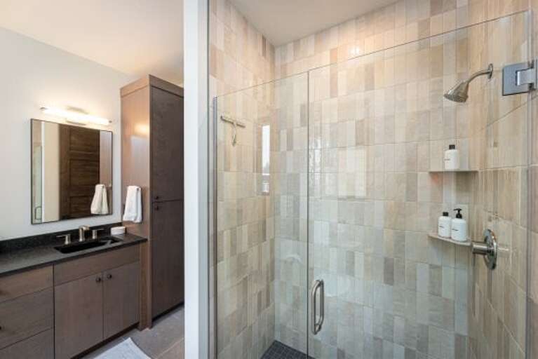 The primary bedroom features a walk-in custom tile shower | Main Level
