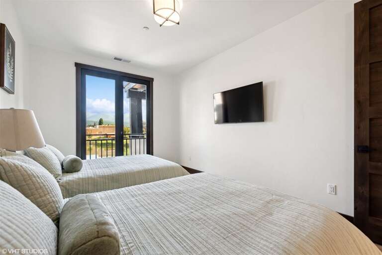 The guest bedroom offers two full-size beds and a private television | Main Level