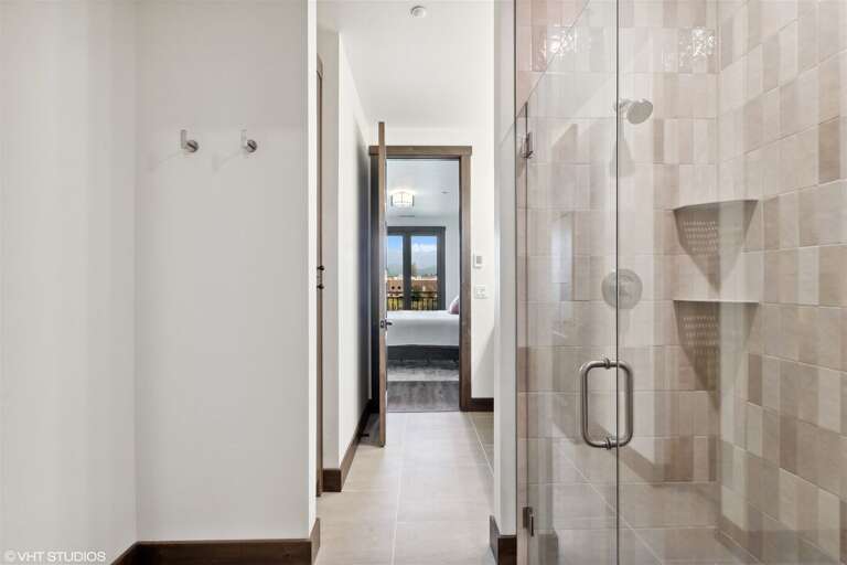 Offering a double vanity, custom tile shower, and heated floors, the primary ensuite is a spa-like retreat | Main Level