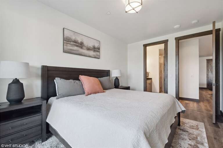 The primary suite offers a king bed, private television, walk-in closet, and luxurious ensuite | Main Level