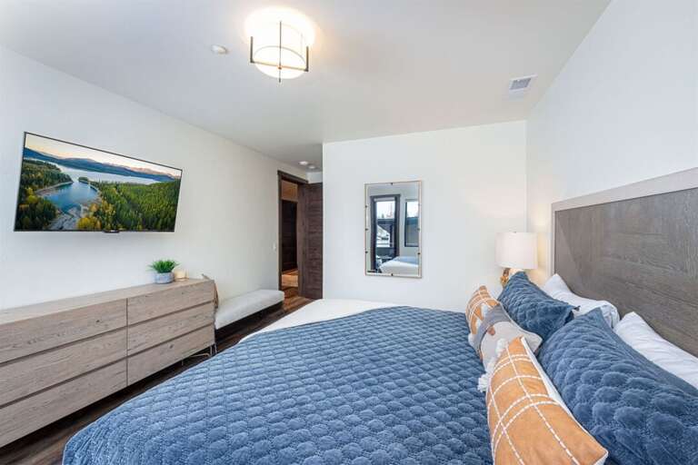 The primary suite offers a king bed with luxurious bedding, a television & private patio | Main Level