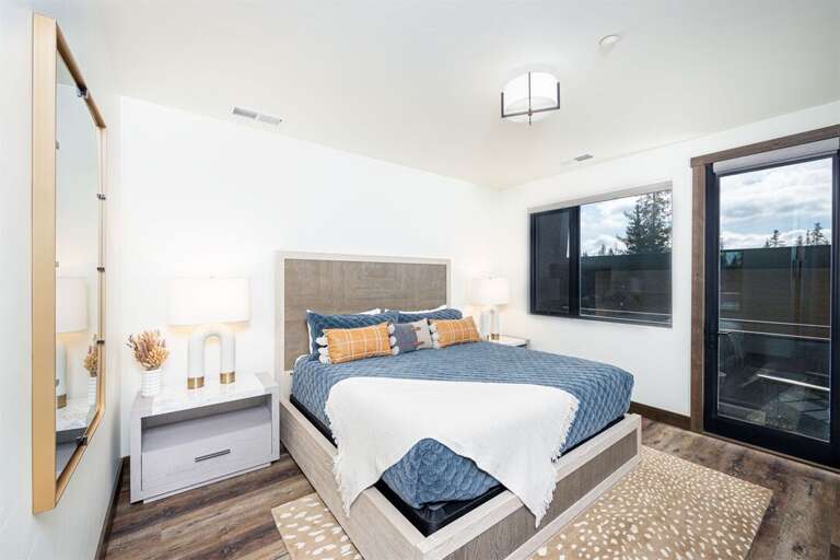 The primary suite offers a modern retreat with spa-like ensuite, walk in closet, private patio & television | Main Level