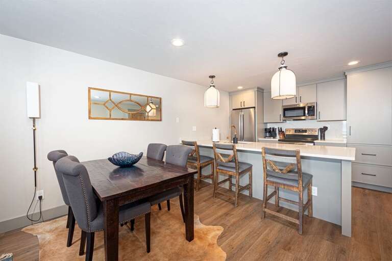 The dining table offers seating for four guests, with seating for an additional three at the kitchen bar | Main Level