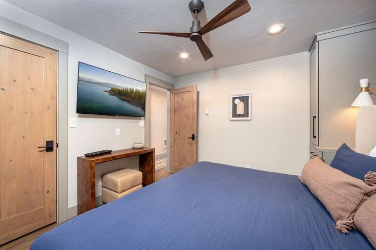 The primary bedroom offers a cozy king bed & private television | Main Level