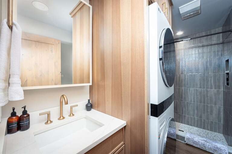 The bathroom offers access to laundry machines | Main Level