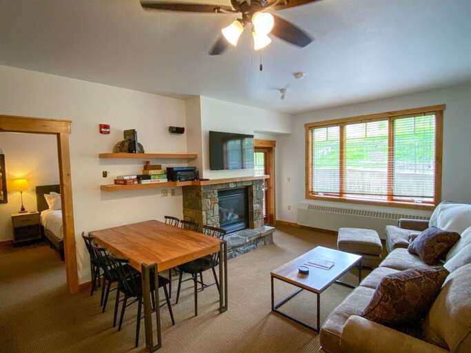 The living room features an oversized couch, a gas fireplace & walkout access to the ski-in ski-out patio | Main Level