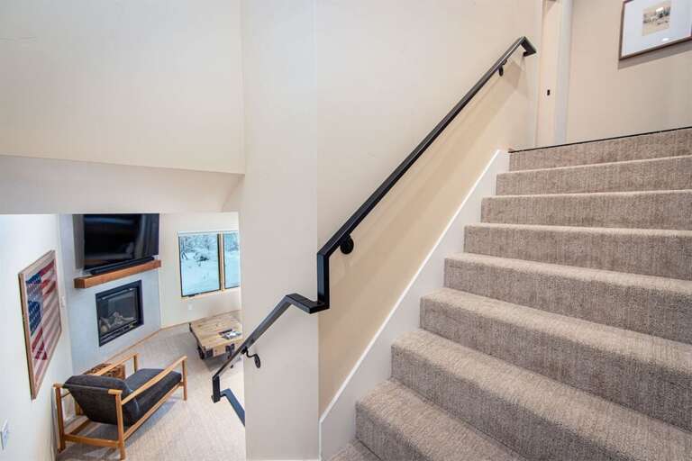 The ground floor hosts the home's second living space with a fireplace & bunk area | Basement Lowest Level