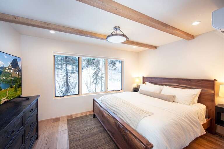 The master bedroom on the top floor of the home features a king bed, private television & luxurious ensuite | Upper Level